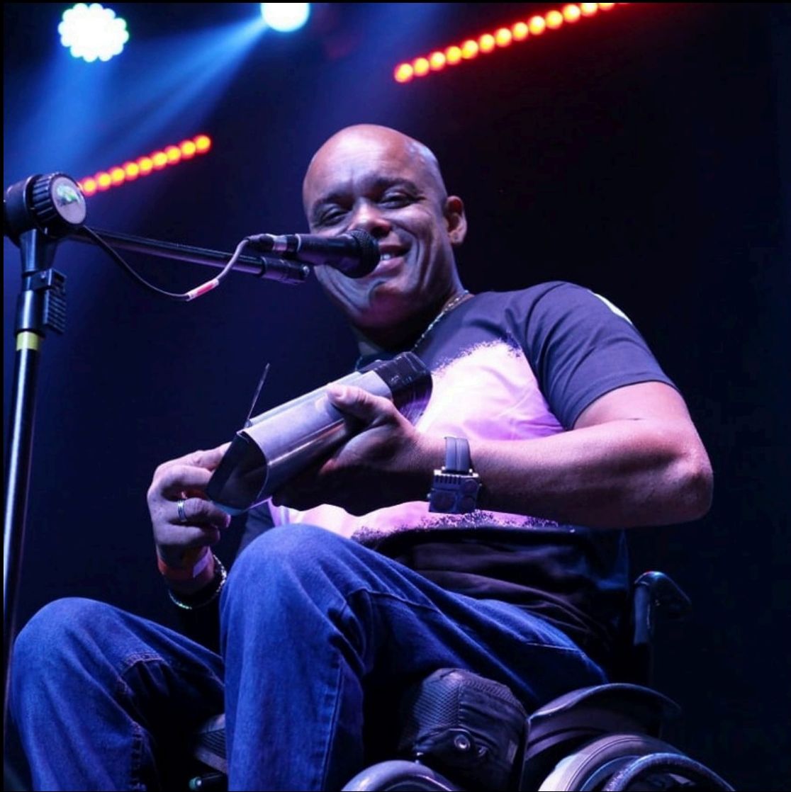 Alexandre Cruz tocando reco-reco no palco